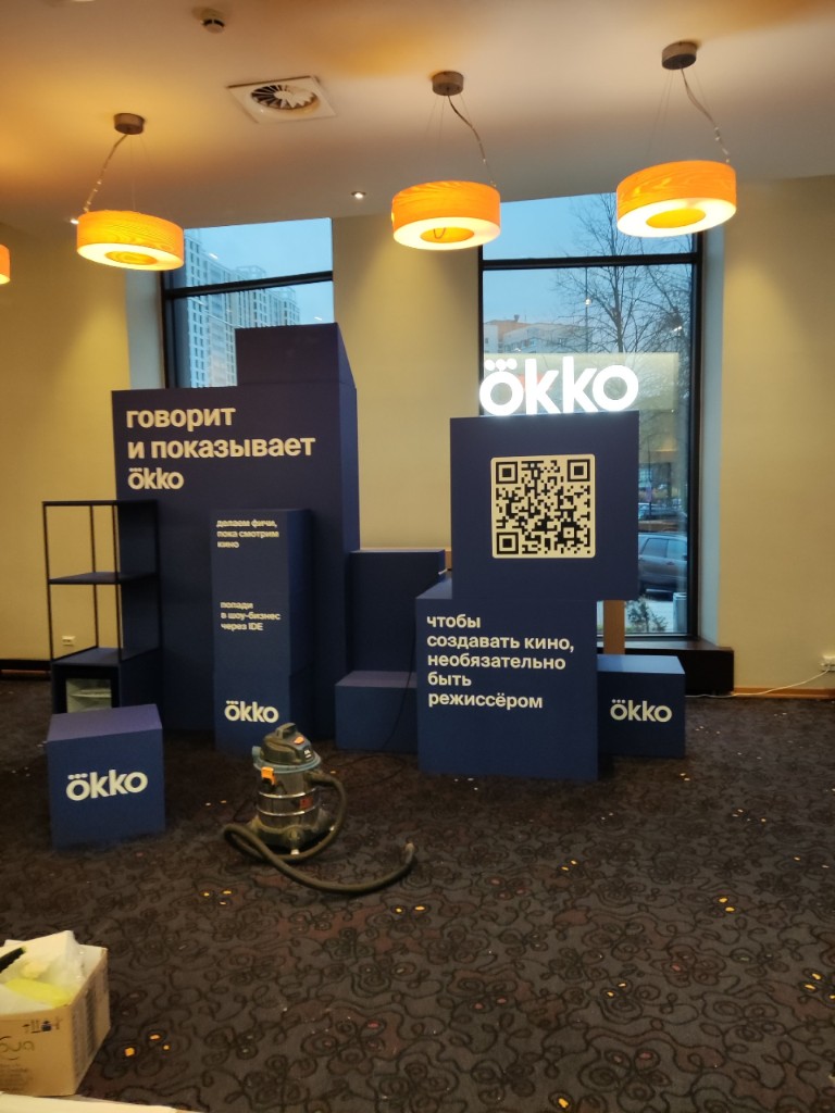 Модульная фотозона ökko: синие блоки с подсветкой, слоганы и QR-код